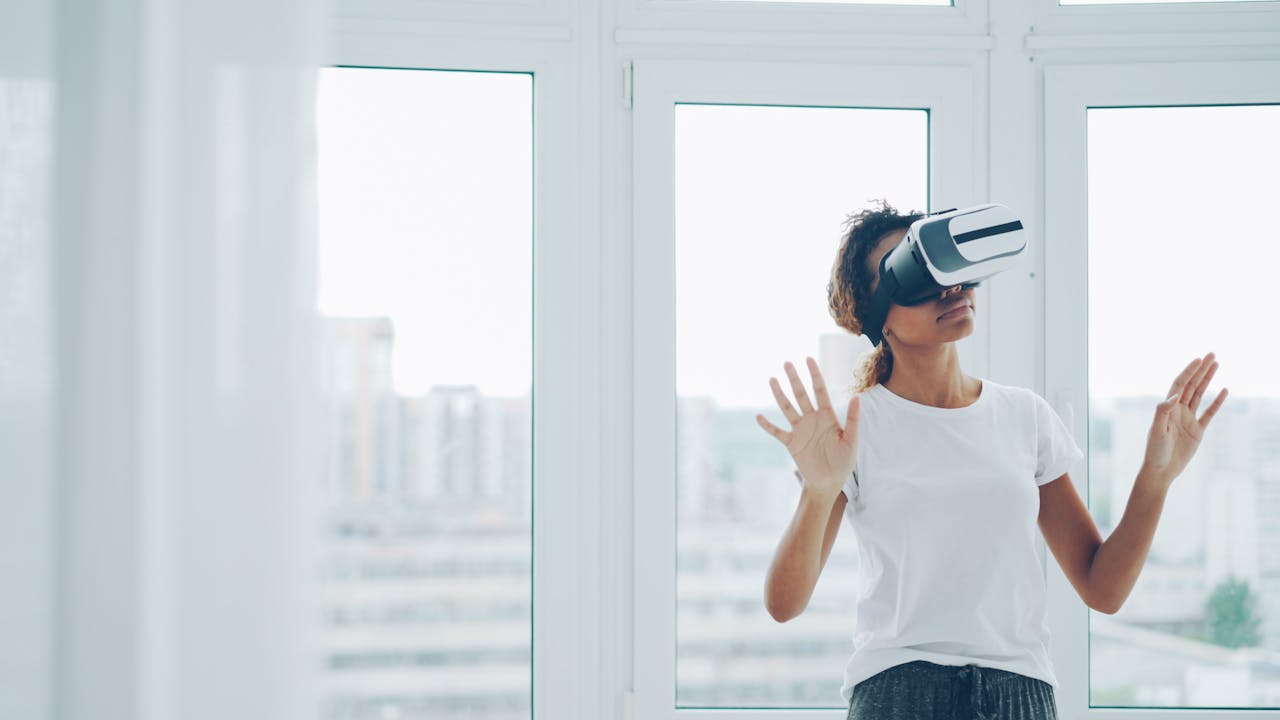 A woman enjoying a virtual reality experience with VR headset indoors.
