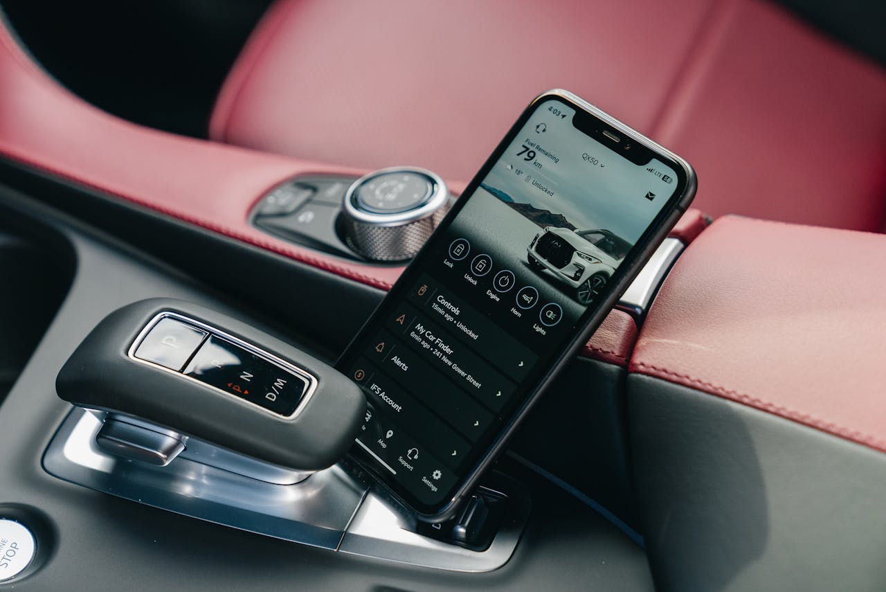 Close-up of smartphone with car control app in a luxury cars interior, showcasing modern technology.